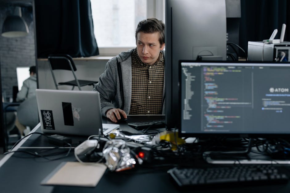 A programmer in a modern office working on computer code.